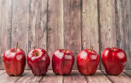 Red apples on weathered wooden backgroundの写真素材