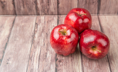 Red apples on weathered wooden backgroundの写真素材
