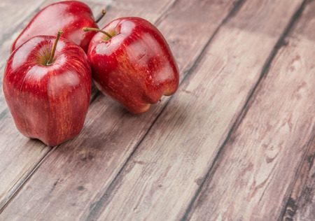 Red apples on weathered wooden backgroundの写真素材