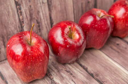 Red apples on weathered wooden backgroundの写真素材