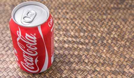 PUTRAJAYA MALAYSIA  JUNE 28TH 2015. Coca Cola can on wicker background. Coca Cola drinks are produced and manufactured by The CocaCola Company an American multinational beverage corporation.のeditorial素材