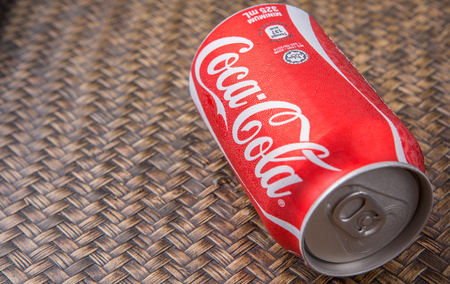 PUTRAJAYA MALAYSIA  JUNE 28TH 2015. Coca Cola can on wicker background. Coca Cola drinks are produced and manufactured by The CocaCola Company an American multinational beverage corporation.のeditorial素材