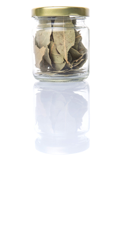 Dried bay leaves herbs in a mason jar over white backgroundの写真素材