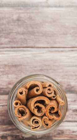 Cinnamon stick spices in a mason jar over weathered wooden backgroundの写真素材