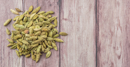 Cardamom spice over weathered wood backgroundの写真素材
