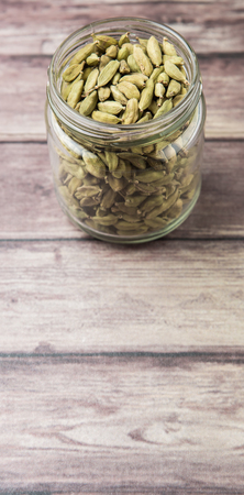 Cardamom spice in a mason jar over weathered wood backgroundの写真素材