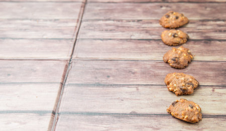 Homemade chocolate chip cookies over weathered wooden surface.の写真素材