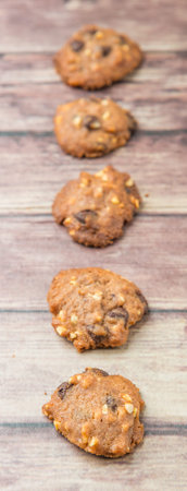 Homemade chocolate chip cookies over weathered wooden surface.の写真素材