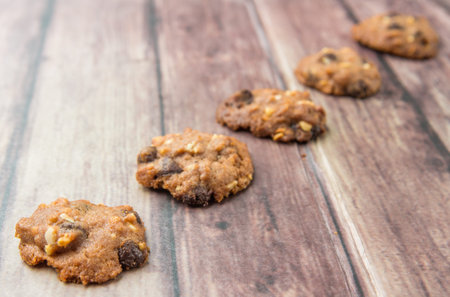 Homemade chocolate chip cookies over weathered wooden surface.