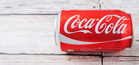 PUTRAJAYA, MALAYSIA - JULY 5TH, 2015. Coca Cola can on weathered wood. Coca Cola drinks are produced...