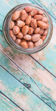Ground nut or peanuts in a mason jar over weathered wooden backgroundの写真素材