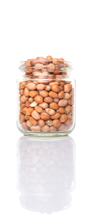 Peanuts or ground nuts in a mason jar over white backgroundの写真素材