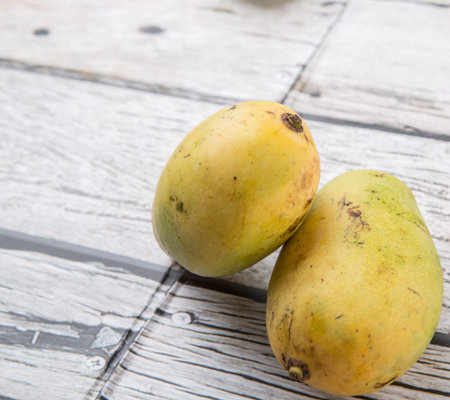 Exotic mango fruits over weathered wooden background