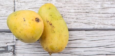 Exotic mango fruits over weathered wooden backgroundの写真素材