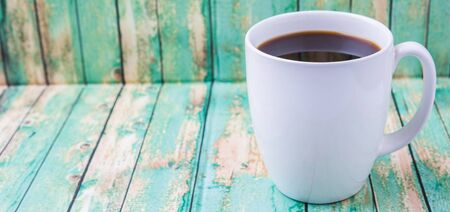 A mug of coffee drink over rustic weathered wooden backgroundの写真素材
