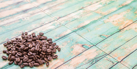 Roasted coffee beans over rustic wooden backgroundの写真素材
