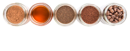 Coffee beans, powdered coffee, chocolate powder and processed tea leaves beverages in white bowls over white backgroundの写真素材