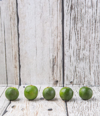 Calamansi citrus over weathered wooden backgroundの写真素材