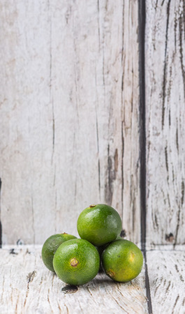 Calamansi citrus over weathered wooden backgroundの写真素材