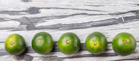 Calamansi citrus over weathered wooden backgroundの写真素材