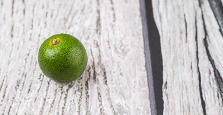 Calamansi citrus over weathered wooden backgroundの写真素材