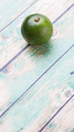 Calamansi citrus over weathered wooden backgroundの写真素材