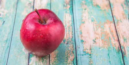 Red apple fruit over weathered wooden backgroundの写真素材