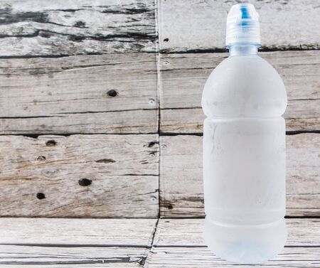 A bottle of mineral water over wooden backgroundの写真素材