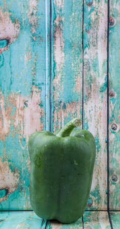 Fresh green bell pepper on a rustic wooden backgroundの写真素材