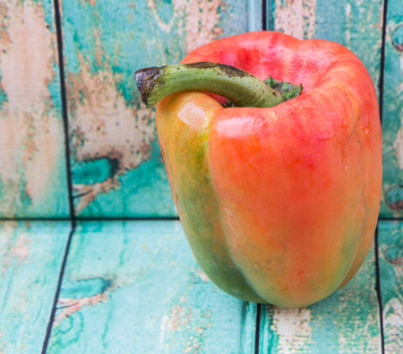 Fresh orange bell pepper on a rustic wooden backgroundの写真素材