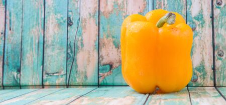 Fresh yellow bell pepper on a rustic wooden backgroundの写真素材