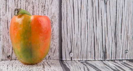 Fresh orange bell pepper on a rustic wooden backgroundの写真素材