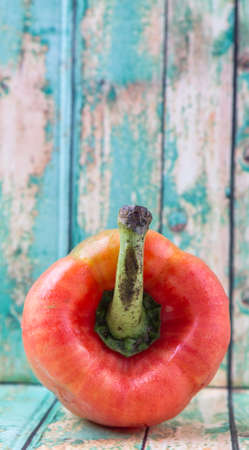 Fresh orange bell pepper on a rustic wooden backgroundの写真素材
