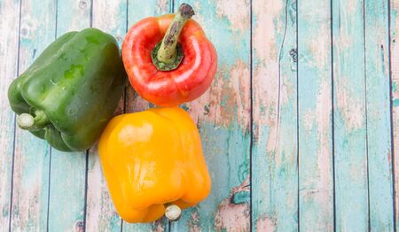 Fresh bell peppers on a rustic wooden backgroundの写真素材