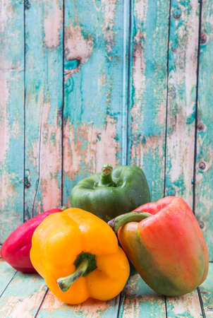 Fresh bell peppers on a rustic wooden backgroundの写真素材