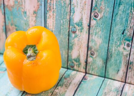 Fresh yellow bell pepper on a rustic wooden backgroundの写真素材
