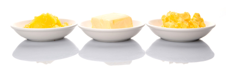 A block of butter, margarine and ghee in white bowlsの写真素材