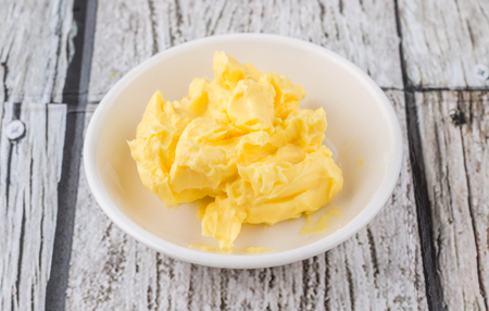A bowl of margarine in white bowl over wooden backgroundの写真素材