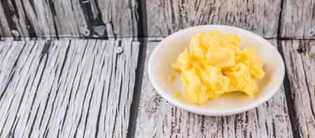 A bowl of margarine in white bowl over wooden backgroundの写真素材