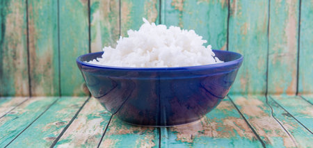 Cooked steamed rice in a blue bowl over wooden backgroundの写真素材