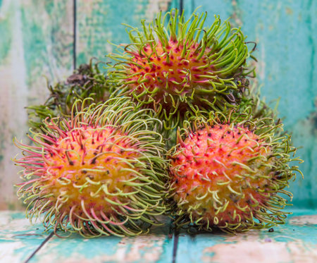 Sweet, exotic and delicious rambutan fruit over wooden background