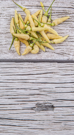 Thai chili or bird\'s eye chilies over wooden backgroundの写真素材