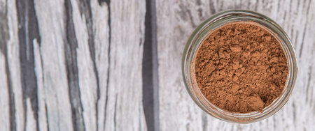 Brown pure cocoa powder in a mason jar over rustic wooden backgroundの写真素材