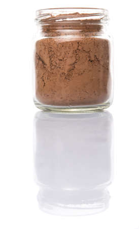 Brown pure cocoa powder in a mason jar over white backgroundの写真素材