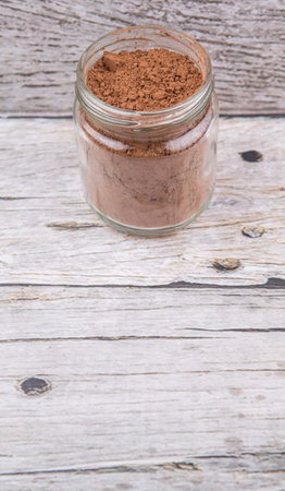 Brown pure cocoa powder in a mason jar over rustic wooden backgroundの写真素材