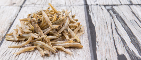 Raw anchovies over rustic wooden backgroundの写真素材