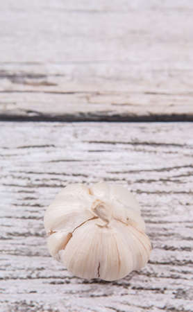 A clove of garlic over rustic wooden backgroundの写真素材