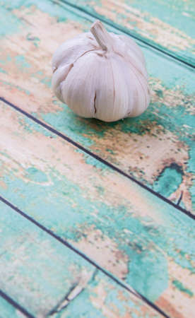 A clove of garlic over rustic wooden backgroundの写真素材