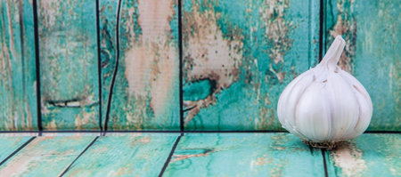 A clove of garlic over rustic wooden backgroundの写真素材