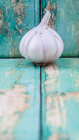 A clove of garlic over rustic wooden backgroundの写真素材